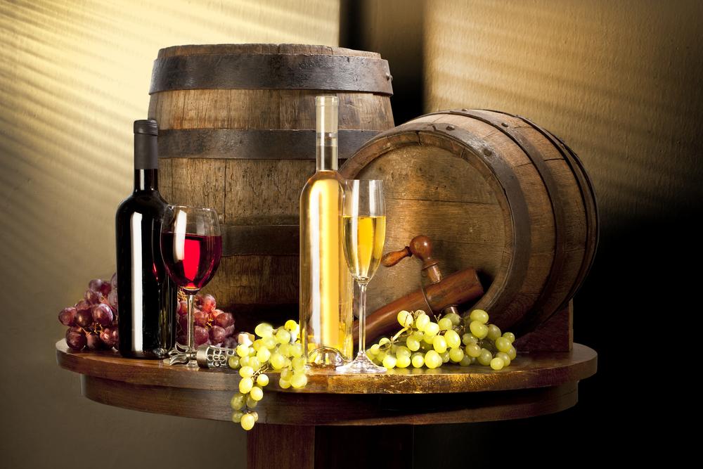 Zwei Deo-Weinfässer mit Trauben und Weinflaschen